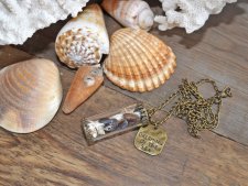 Hänge med snäckor och sjöstjärna i glasbehållare, dekorerad med bronspläterad berlock med texten Dreaming of the sea. Levereras