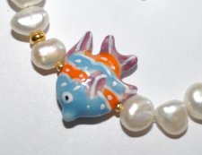 Unikt mismatched armband med sötvattenspärlor, ljusblå porslinspärlor och tropisk fisk-berlock i porslin. Tillverkat med 18K gul