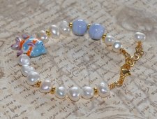 Unikt mismatched armband med sötvattenspärlor, ljusblå porslinspärlor och tropisk fisk-berlock i porslin. Tillverkat med 18K gul