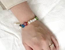 Färgstarkt Y2K-armband med vita sötvattenspärlor, guldfärgade seed beads och lekfulla millefiori-blomglaspärlor, justerbart med