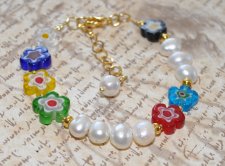 Färgstarkt Y2K-armband med vita sötvattenspärlor, guldfärgade seed beads och lekfulla millefiori-blomglaspärlor, justerbart med