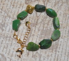 Handgjort boho luxe-armband med gröna chrysopraspärlor, mönstrad mässingspärla och delfinberlock i 18K guldpläterat rostfritt st