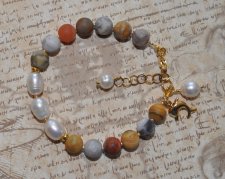 Handgjort armband med frostade Crazy Lace agatpärlor, vita sötvattenspärlor och delfinberlock i 18K guldpläterat rostfritt stål,