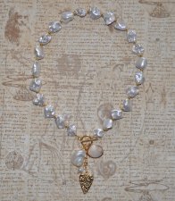 Elegant halsband med sötvattenssnäckor, vit pärla och guldförgyllda detaljer – kustinspirerat statement-smycke med toggle-lås i 