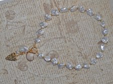 Elegant halsband med sötvattenssnäckor, vit pärla och guldförgyllda detaljer – kustinspirerat statement-smycke med toggle-lås i 