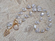 Elegant halsband med sötvattenssnäckor, vit pärla och guldförgyllda detaljer – kustinspirerat statement-smycke med toggle-lås i 