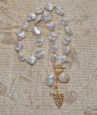 Elegant halsband med sötvattenssnäckor, vit pärla och guldförgyllda detaljer – kustinspirerat statement-smycke med toggle-lås i 