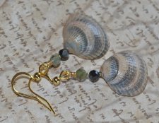 Handgjorda örhängen med hjärtformade snäckor i persika och grått från svenska västkusten, dekorerade med fasetterade svarta och 