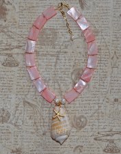 Handgjort halsband med korallrosa pärlemorpärlor, sötvattenspärlor och gyllene seed beads. Center med Alphabet Cone-snäcka och 1