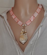 Handgjort halsband med korallrosa pärlemorpärlor, sötvattenspärlor och gyllene seed beads. Center med Alphabet Cone-snäcka och 1