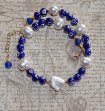 Choker-halsband med vita sötvattensskalpärlor, koboltblå evil eye-porcelänpärlor och frostade blå glaspärlor. 18K guldpläterade 