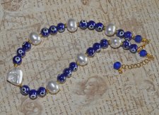 Choker-halsband med vita sötvattensskalpärlor, koboltblå evil eye-porcelänpärlor och frostade blå glaspärlor. 18K guldpläterade 