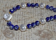 Choker-halsband med vita sötvattensskalpärlor, koboltblå evil eye-porcelänpärlor och frostade blå glaspärlor. 18K guldpläterade 