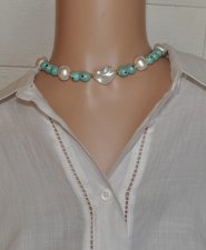 Chokerhalsband med vita snäckskalpärlor, turkosa Evil Eye-detaljer och snäcknugget i mitten. Justerbart halsband i rostfritt stå