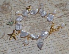 Handgjort armband med vita elektropläterade sötvattensskal-nuggets, snäckor, sötvattenspärlor och 18K guldpläterade delfin- och 