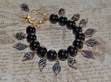 Handgjort Mermaidcore-armband med svart, vitt och brunt snäckskal, svarta porslinspärlor och guldpläterad sjöstjärna. Justerbart
