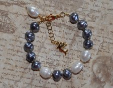 Elegant armband med vita sötvattenspärlor, stålfärgade tjeckiska glaspärlor och gyllene seed beads. Prytt med en droppformad pär