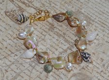 Sommararmband med Alabaster Beige AB snäckpärlor, varma guldfärgade glaspärlor, vita sötvattenspärlor och naturliga snäckor. Jus