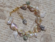 Sommararmband med Alabaster Beige AB snäckpärlor, varma guldfärgade glaspärlor, vita sötvattenspärlor och naturliga snäckor. Jus