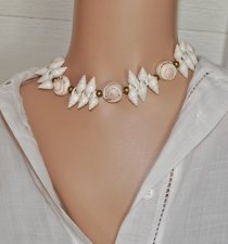 Handgjord naturinspirerad choker med äkta vita spiralformade snäckor, guldfärgade träpärlor och iögonfallande trumpetsnäckor. Ju