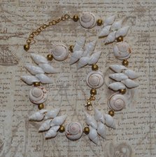 Handgjord naturinspirerad choker med äkta vita spiralformade snäckor, guldfärgade träpärlor och iögonfallande trumpetsnäckor. Ju