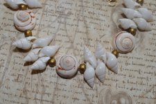 Handgjord naturinspirerad choker med äkta vita spiralformade snäckor, guldfärgade träpärlor och iögonfallande trumpetsnäckor. Ju