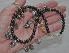 Gotisk sjöjungfru-choker med svarta ebenholtspärlor och mörka spiralformade snäckor. Justerbar längd med 18K guldförgyllda detal