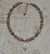 Handgjord choker med varma vintage-kokospärlor, sandelträpärlor och en vacker snäcka som mittpunkt. Justerbar längd med 18K guld