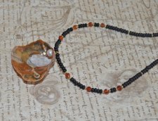Handgjort mermaidcore choker-halsband med färgglada tjeckiska seed beads, fasetterad hessonit-garnet och en delikat guldmussla i