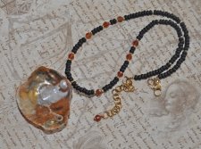 Handgjort mermaidcore choker-halsband med färgglada tjeckiska seed beads, fasetterad hessonit-garnet och en delikat guldmussla i