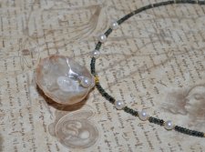 Handgjort chokerhalsband med svart och olivgrön tjeckisk glaspärla, vita sötvattenspärlor och en naturlig guldmussla med pärla. 