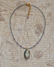 Handgjort mermaidcore choker-halsband med iriserande seed beads och facetterade ametistpärlor, prytt med en naturlig paua-snäcka