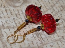 Vintage 1970-tals örhängen i lingonröd akryl med facetterade svarta spinellpärlor, guldfärgade bugle beads, mässingsdetaljer och