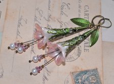 Handgjorda örhängen med handmålade luciteblommor i skimrande pärlemor och mjukt rosa, toppade med antique bronze-filigrankåpor. 