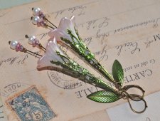 Handgjorda örhängen med handmålade luciteblommor i skimrande pärlemor och mjukt rosa, toppade med antique bronze-filigrankåpor. 