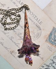 Handgjort OOAK-halsband med stor frostad lucite-blomma handmålad i svart vinbär, lila, sienna och guld. Dekorerad med filigranko