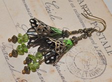 Handgjorda örhängen i Fairycore-stil med bronsfärgade filigranblommor och polerade peridotpärlor som glimmar i grönt. De svängan