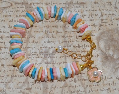 Handgjort sommararmband med färgglada snäckbitar, emaljerad blomcharm och vit sötvattenspärla. Justerbart med 3 cm förlängningsk