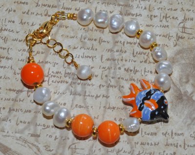 Unikt handgjort armband med vita sötvattenspärlor, orange porslinspärlor och tropisk fisk-berlock. Tillverkat med 18K guldpläter