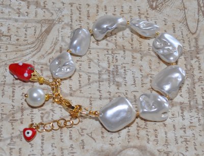 Handgjort Y2K-armband med vita elektropläterade snäcknuggets, gyllene seed beads, jordgubbs-charm och vit faux perle. Justerbart