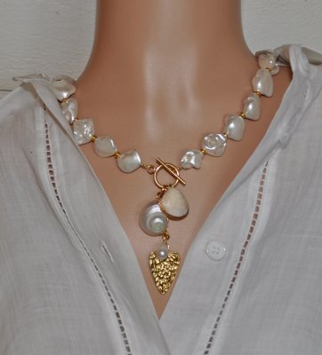 Elegant halsband med sötvattenssnäckor, vit pärla och guldförgyllda detaljer – kustinspirerat statement-smycke med toggle-lås i 