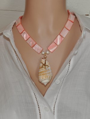 Handgjort halsband med korallrosa pärlemorpärlor, sötvattenspärlor och gyllene seed beads. Center med Alphabet Cone-snäcka och 1