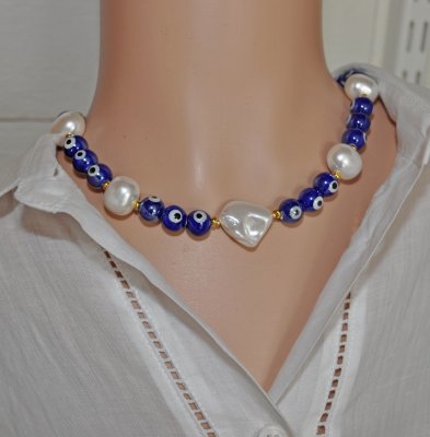 Choker-halsband med vita sötvattensskalpärlor, koboltblå evil eye-porslinspärlor och frostade blå glaspärlor. 18K guldpläterade 