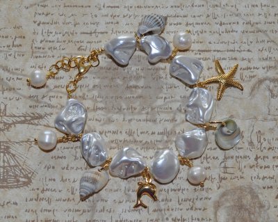 Handgjort armband med vita elektropläterade sötvattensskal-nuggets, snäckor, sötvattenspärlor och 18K guldpläterade delfin- och 