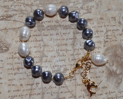 Elegant armband med vita sötvattenspärlor, stålfärgade tjeckiska glaspärlor och gyllene seed beads. Prytt med en droppformad pär