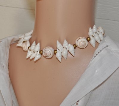 Handgjord naturinspirerad choker med äkta vita spiralformade snäckor, guldfärgade träpärlor och iögonfallande trumpetsnäckor. Ju
