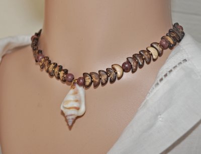 Handgjord choker med varma vintage-kokospärlor, sandelträpärlor och en vacker snäcka som mittpunkt. Justerbar längd med 18K guld