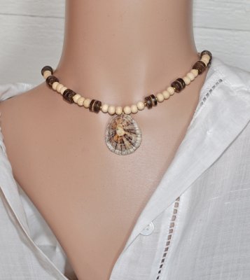 Handgjort mermaidcore choker-halsband med naturliga träpärlor och kokos-heishi-pärlor, centralt prytt med en unik limpetsnäcka. 