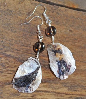 Unika handgjorda örhängen med bruna och vita ostronsnäckor från svenska västkusten och runda rökkvartspärlor. Silverpläterade kr