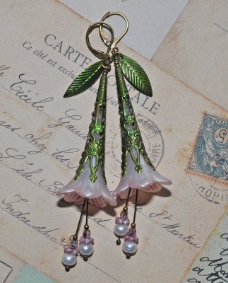 Handgjorda örhängen med handmålade luciteblommor i skimrande pärlemor och mjukt rosa, toppade med antique bronze-filigrankåpor. 